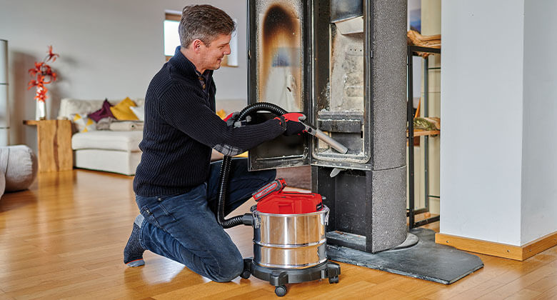 man cleaning an oven with an ash vacuum cleaner