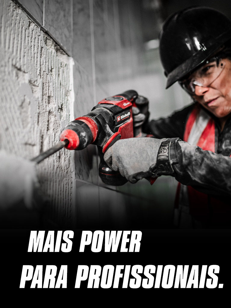 Uma pessoa a usar óculos de segurança e um capacete opera um berbequim vermelho numa parede, com o texto "Mais Potência para Profissionais".