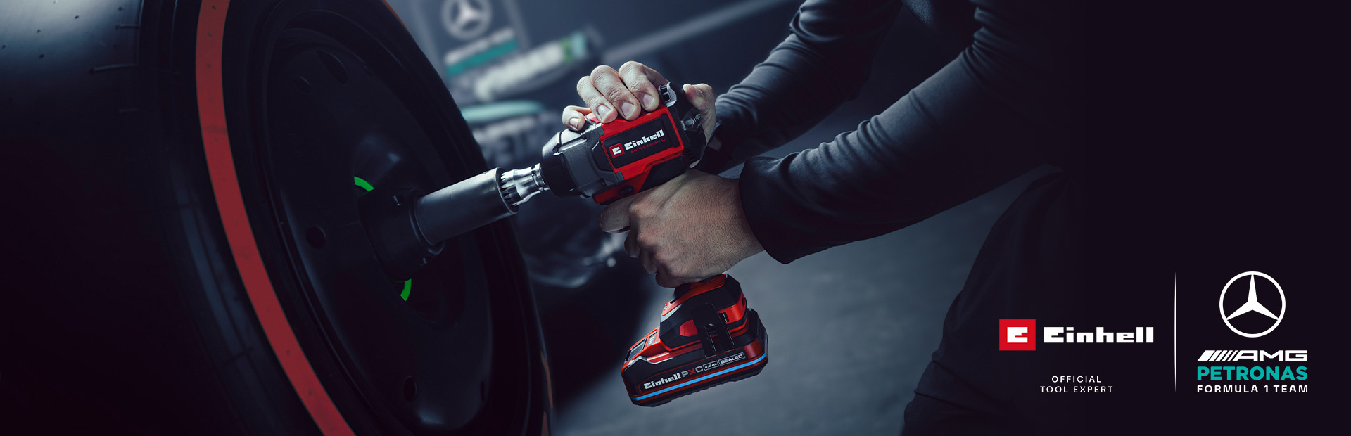 Chave de impacto sem fio Einhell em uso numa roda de carro, com o branding e o logótipo de parceria da equipa Mercedes-AMG Petronas de Fórmula 1