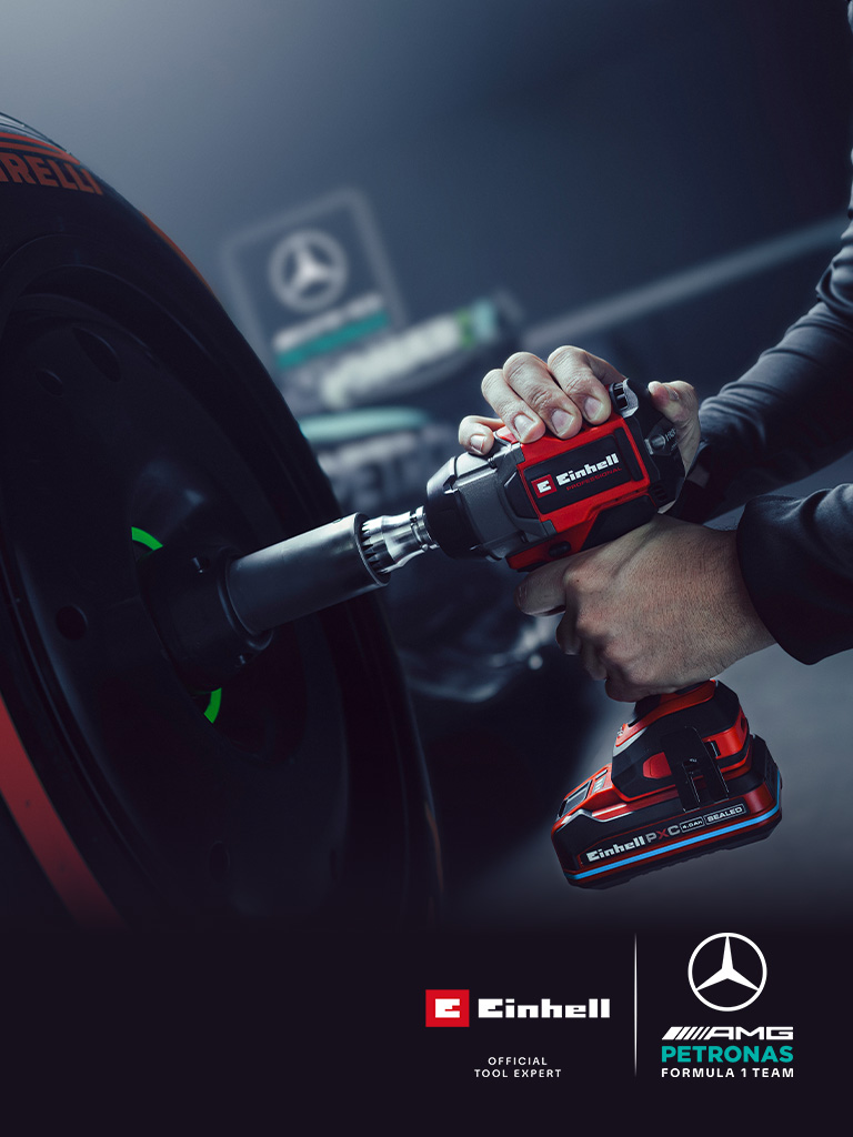 Chave de impacto sem fio Einhell em uso numa roda de carro, com o branding e o logótipo de parceria da equipa Mercedes-AMG Petronas de Fórmula 1