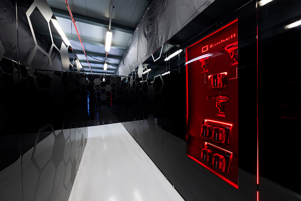 Corredor do box de Fórmula 1 no pit lane com iluminação vermelha.