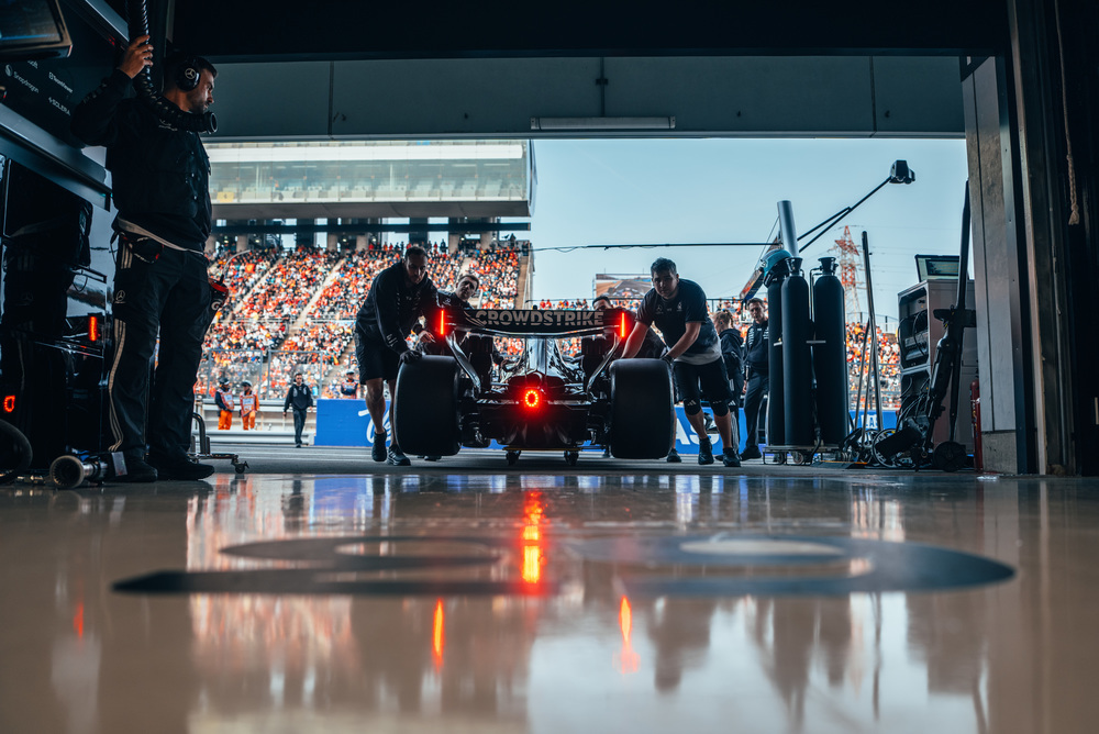 Carro F1 Mercedes na garagem com equipamentos e luzes