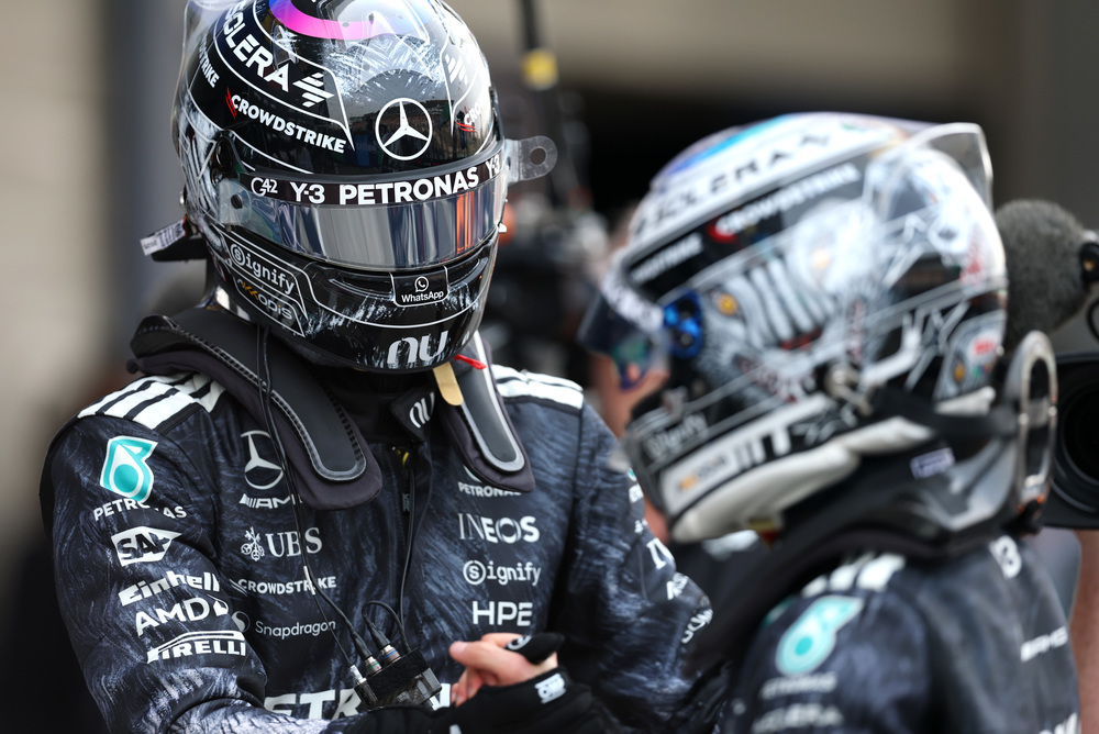 Dois pilotos Mercedes F1 com fatos e capacetes