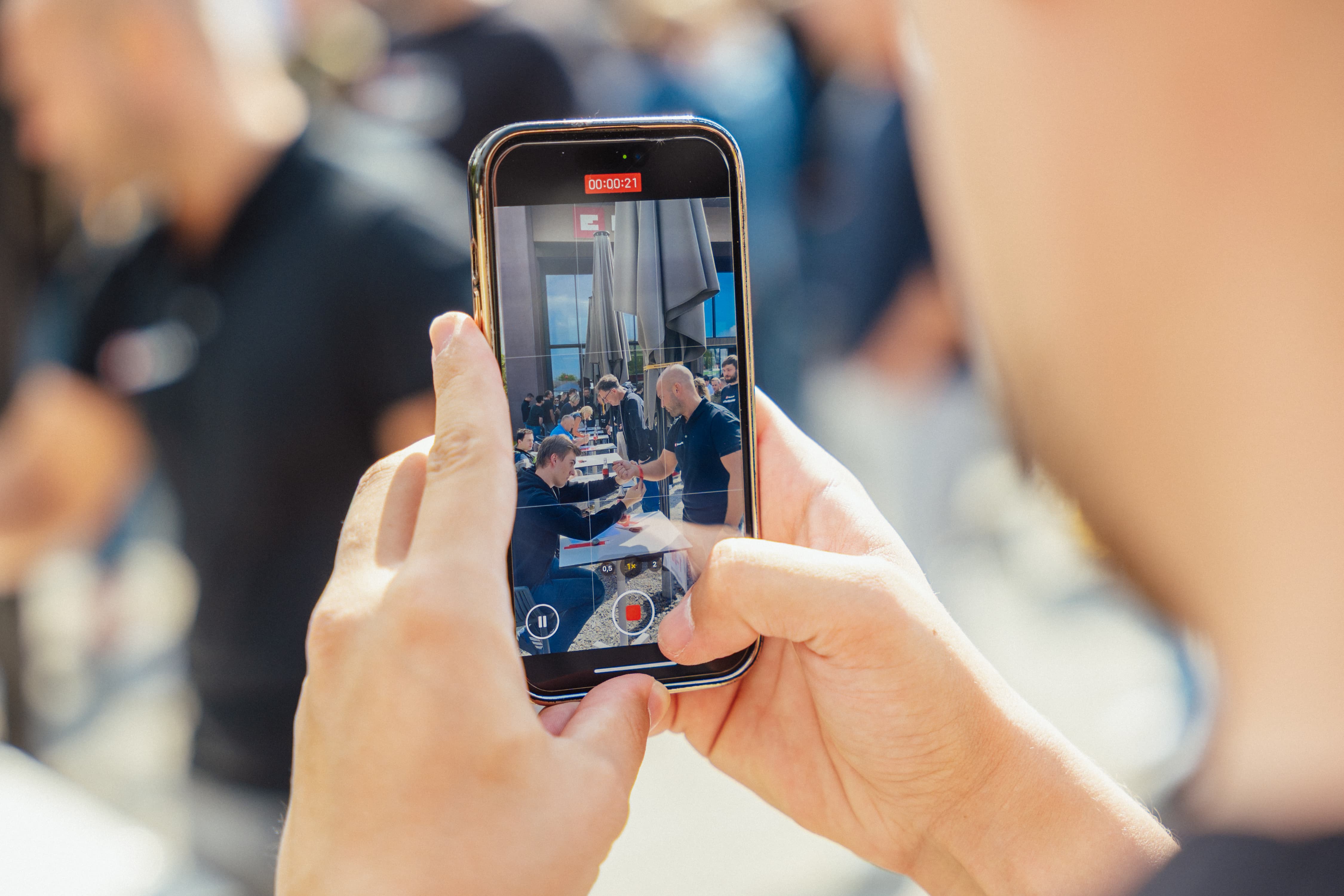 Plano aproximado de um smartphone a gravar um vídeo de um aperto de mão no evento da Einhell.